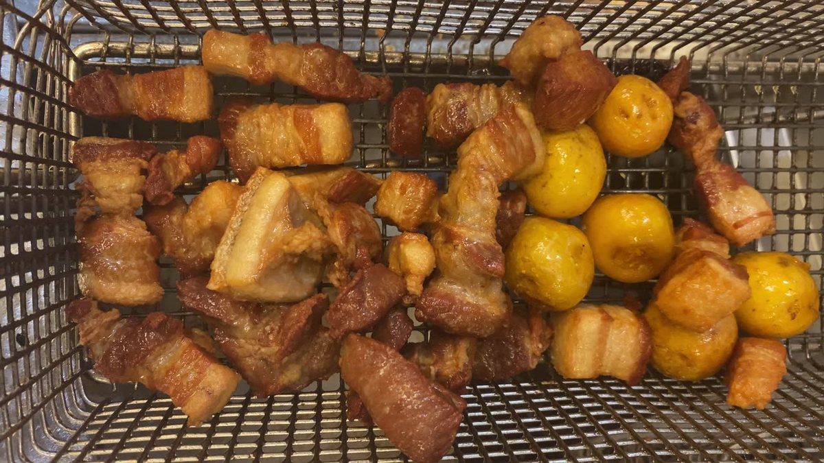 Chicharrón and papa criolla coming out of the fryer in the Casa Colombia kitchen