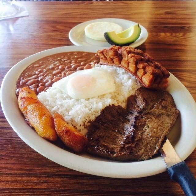 Bandeja paisa at Casa Colombia — grilled steak, red beans, white rice, chicharrón, sweet plantain, a fried egg, arepa and avocado